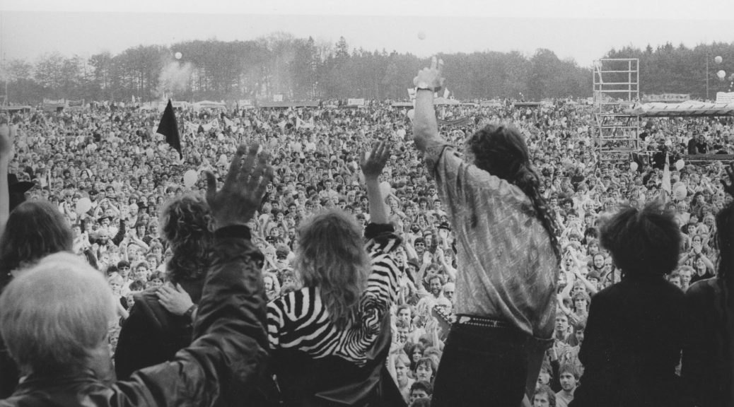 Blick von der Bühne über die Menge bei der Großdemonstration 1986, Menschen mit erhobenen Händen